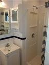 Bathroom with vanity, a shower with curtain, and tile walls