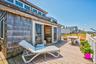 Spacious outdoor deck featuring composite flooring and a wooden privacy fence