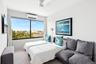 Carpeted bedroom featuring ceiling fan and a wall mounted AC