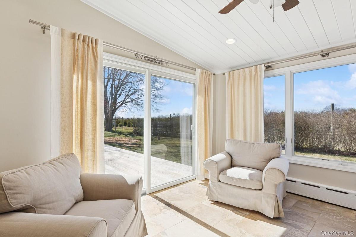 Sunroom / solarium featuring vaulted ceiling, a baseboard heating unit, wooden ceiling, and recessed lighting