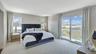 Bedroom featuring a water view, access to outside, carpet, and visible vents