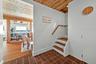 Interior staircase featuring wood treads and handrail, with terracotta tile flooring
