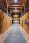 The main barn center aisle, matted stalls, yoked windows, fire suppression system, automatic fly control system, climate-controlled tack room with kit