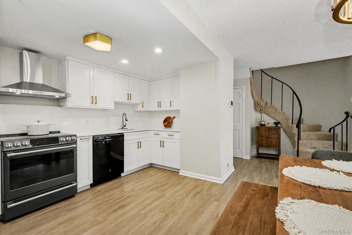 Abundant natural light fills both the kitchen and dining area, while thoughtfully selected decorative lighting adds warmth and character, creating an