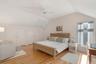Bedroom with vaulted ceiling, two closets, light wood-style floors, and a ceiling fan