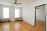 Empty room featuring a ceiling fan, radiator, and light wood-style flooring