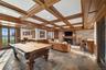 Game room featuring billiards, a glass covered fireplace, wainscoting, french doors, and coffered ceiling