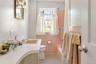 Full bathroom with shower / tub combo, toilet, tile patterned floors, vanity, and tile walls