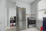 White walls with a window, stainless steel refrigerator, and stainless steel range