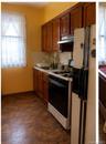 Kitchen featuring wood cabinetry, a built-in range with a range hood, and tile flooring