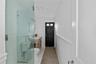 Bathroom with an enclosed shower, vanity, tile patterned floors, and toilet