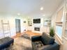 Living room with built in features and light hardwood / wood-style flooring