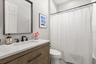 Shared secondary bath with updated vanity, toilet, lighting and fixtures