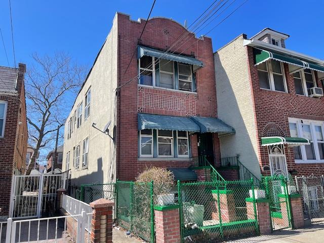 Multi unit property with a gate, a fenced front yard, and brick siding