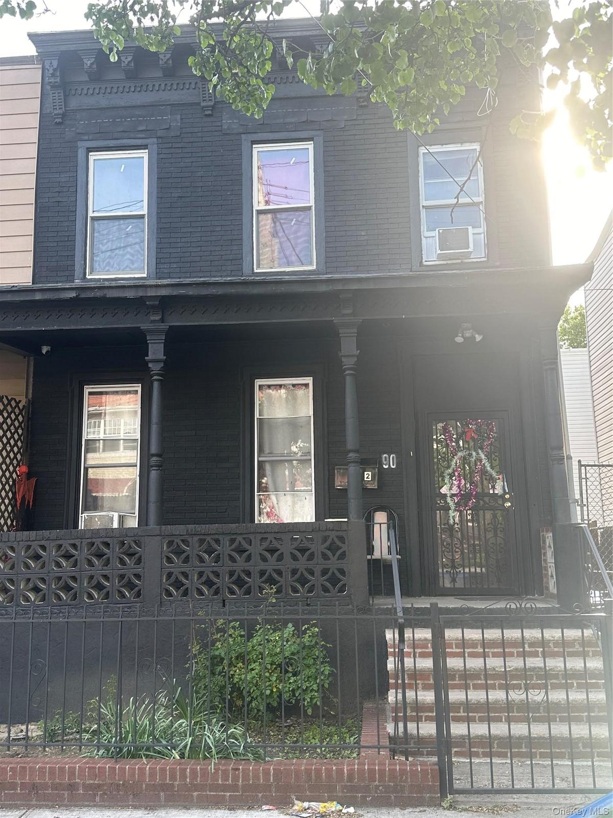 View of front facade featuring covered porch and a fenced front yard