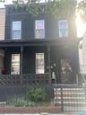 View of front facade featuring covered porch and a fenced front yard
