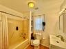 4 - Bathroom with toilet, vanity, shower / bath combo, wood finished floors, and visible vents