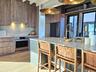 Kitchen with extractor fan, light countertops, stainless steel oven, and modern cabinets