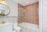 Full bathroom featuring tile walls, tiled shower / bath combo, vanity, and recessed lighting