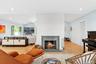 Living area featuring lofted ceiling, recessed lighting, light wood finished floors, and a brick fireplace