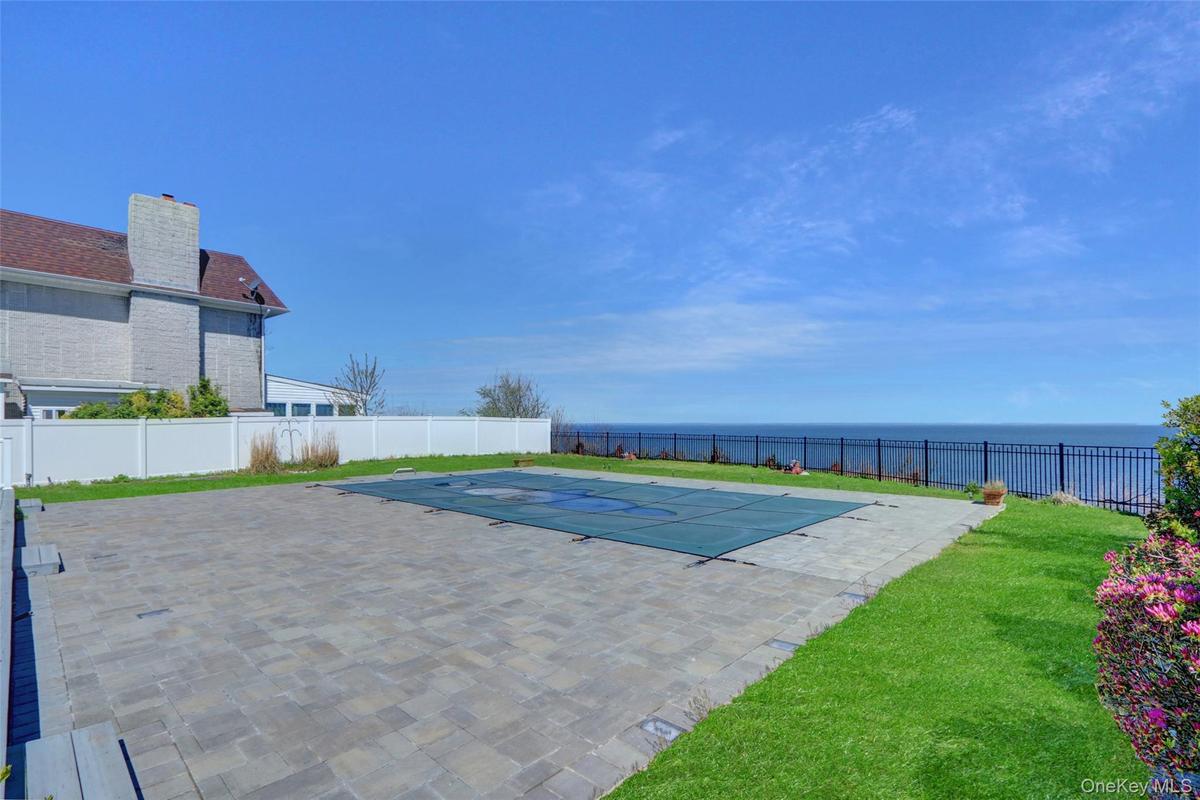 View of pool featuring a water view, a fenced backyard, and a patio area