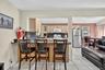 Kitchen featuring tasteful backsplash, light brown cabinets, white appliances, a kitchen bar, and dark countertops
