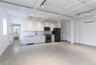 Kitchen with white cabinets, black appliances, light countertops, tasteful backsplash, and a wall mounted air conditioner