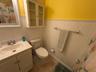 Bathroom with wainscoting, a shower with shower curtain, vanity, light tile patterned floors, and wood walls
