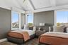 Bedroom with lofted ceiling, wallpapered walls, and wood finished floors