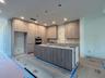(as of April 8, 2026) the kitchen anchors the first floor living space, quartz countertops to be installed, featuring kitchen aid professional applian