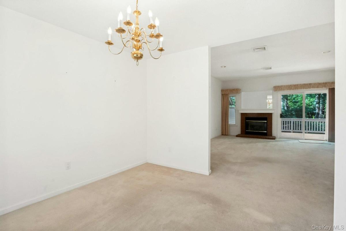 With view to living room with fireplace* & sliding glass doors to rear deck and yard*fireplace has not been used..