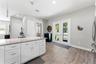 Open-concept kitchen with solid-wood cabinetry, granite countertops, stainless steel appliances, and custom lighting including under-counter kitchen l