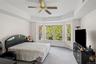 Carpeted bedroom featuring a tray ceiling and ceiling fan