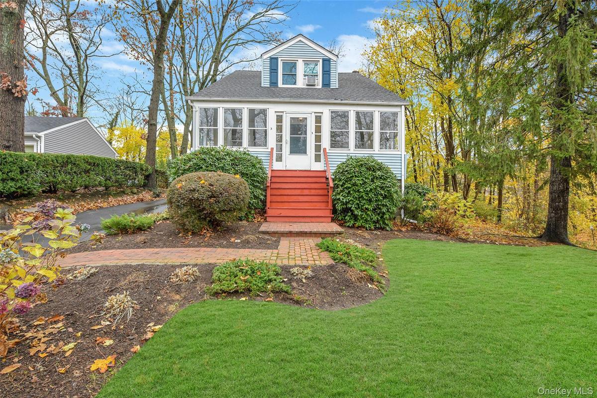 Light blue siding exterior with white trim, red-painted steps, and an enclosed front porch