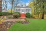 Light blue siding exterior with white trim, red-painted steps, and an enclosed front porch