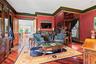 Hardwood flooring throughout, featuring a fireplace with a marble surround and ornate mantel