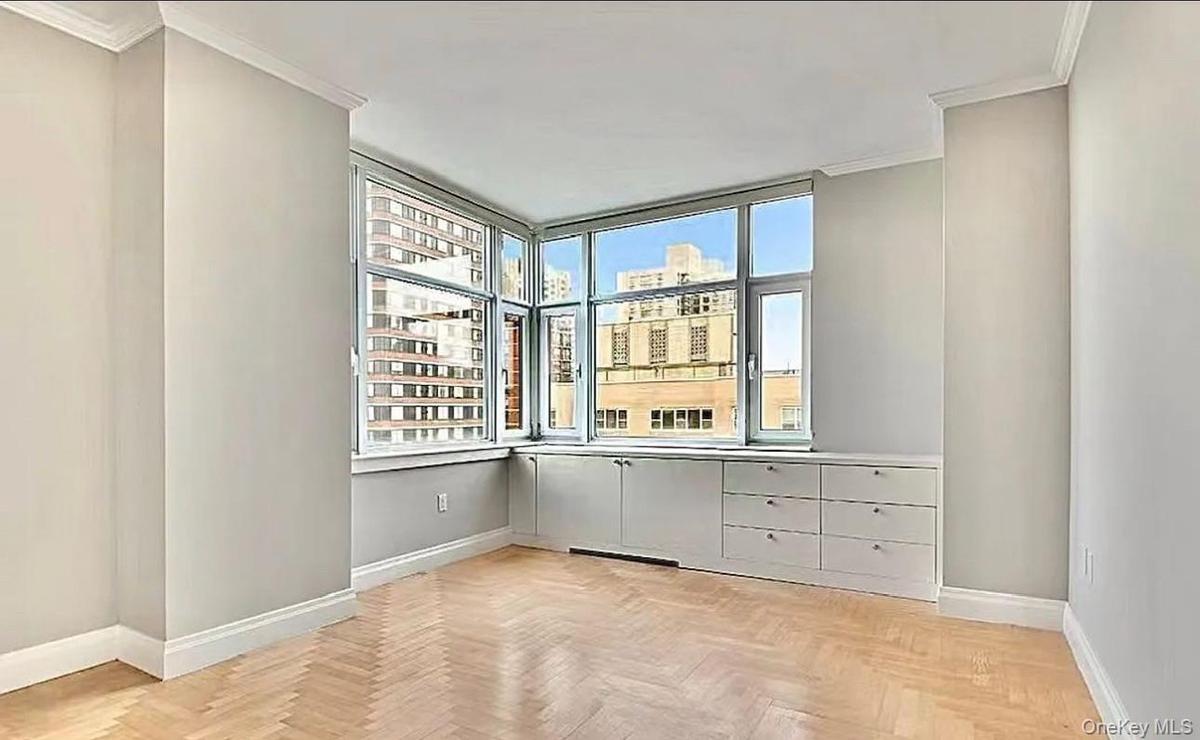 Spare room featuring a view of city, ornamental molding, and plenty of natural light