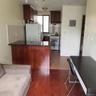 Kitchen featuring dark wood-style flooring, white appliances, a peninsula, a breakfast bar area, and dark brown cabinetry