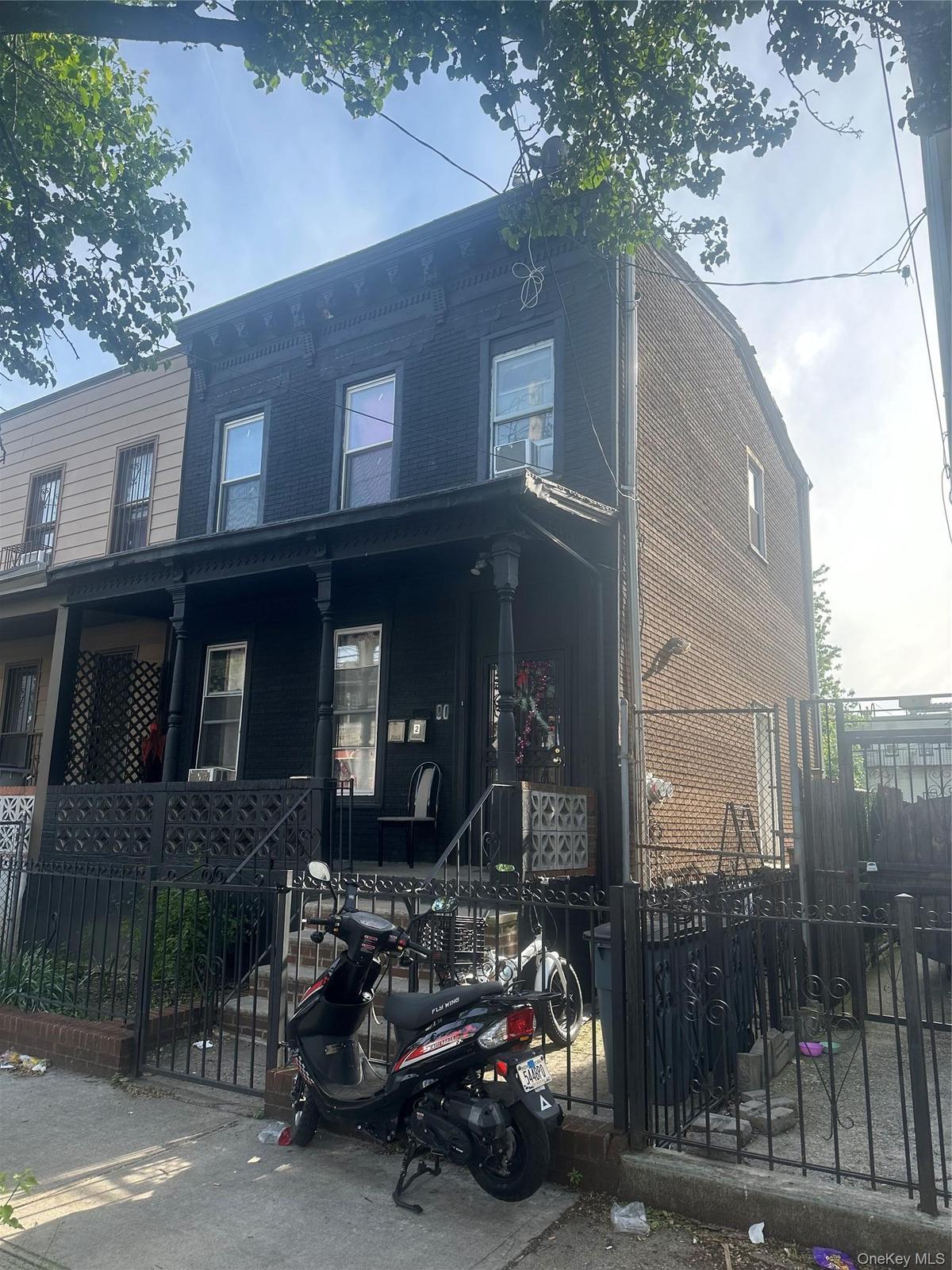 View of front facade with covered porch and a fenced front yard
