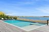 View of swimming pool featuring a water view and a pool with connected hot tub