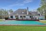 Back of house with a yard, a chimney, a fenced in pool, and a wooden deck