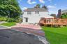 Back of property with a yard, a chimney, and a wooden deck