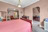 Second floor apartment bedroom with archway into living room and bonus room.