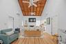 Living room featuring high vaulted ceiling, a fireplace, wood finished floors, and wood ceiling