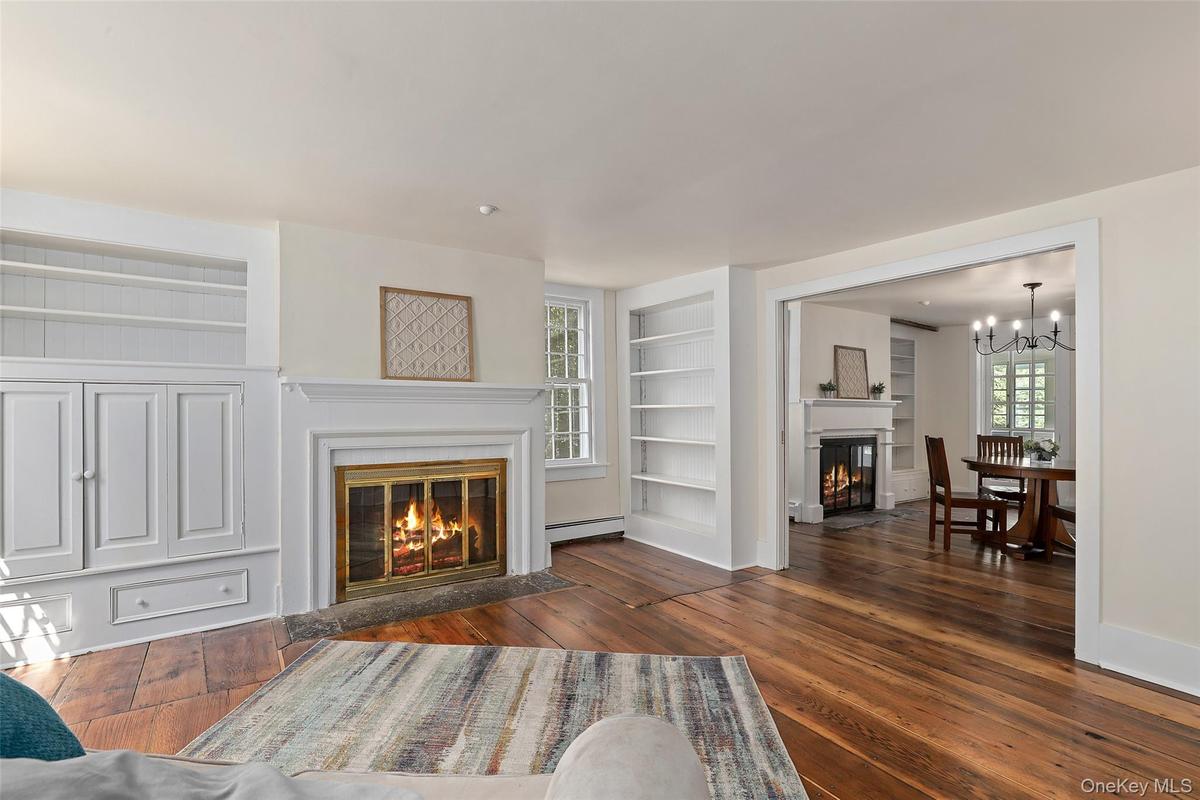 Wood burning fire place in the formal living room open to dining room with pocket doors
