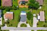 Overhead drone view highlighting the property layout, circular driveway, pool, and spacious yard.