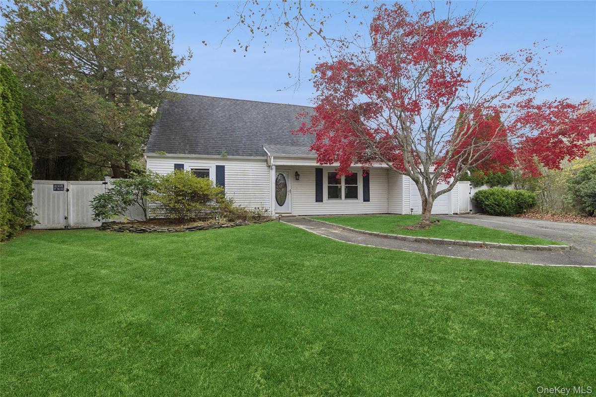 View of front of home with asphalt driveway, roof with shingles, and covered porch
