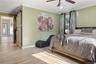 The primary bedroom opens to a contemporary primary bath and hallway.