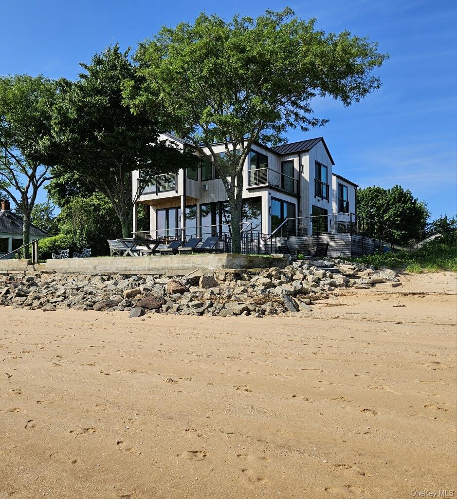 View of front of property featuring a balcony, a standing seam roof, and metal roof