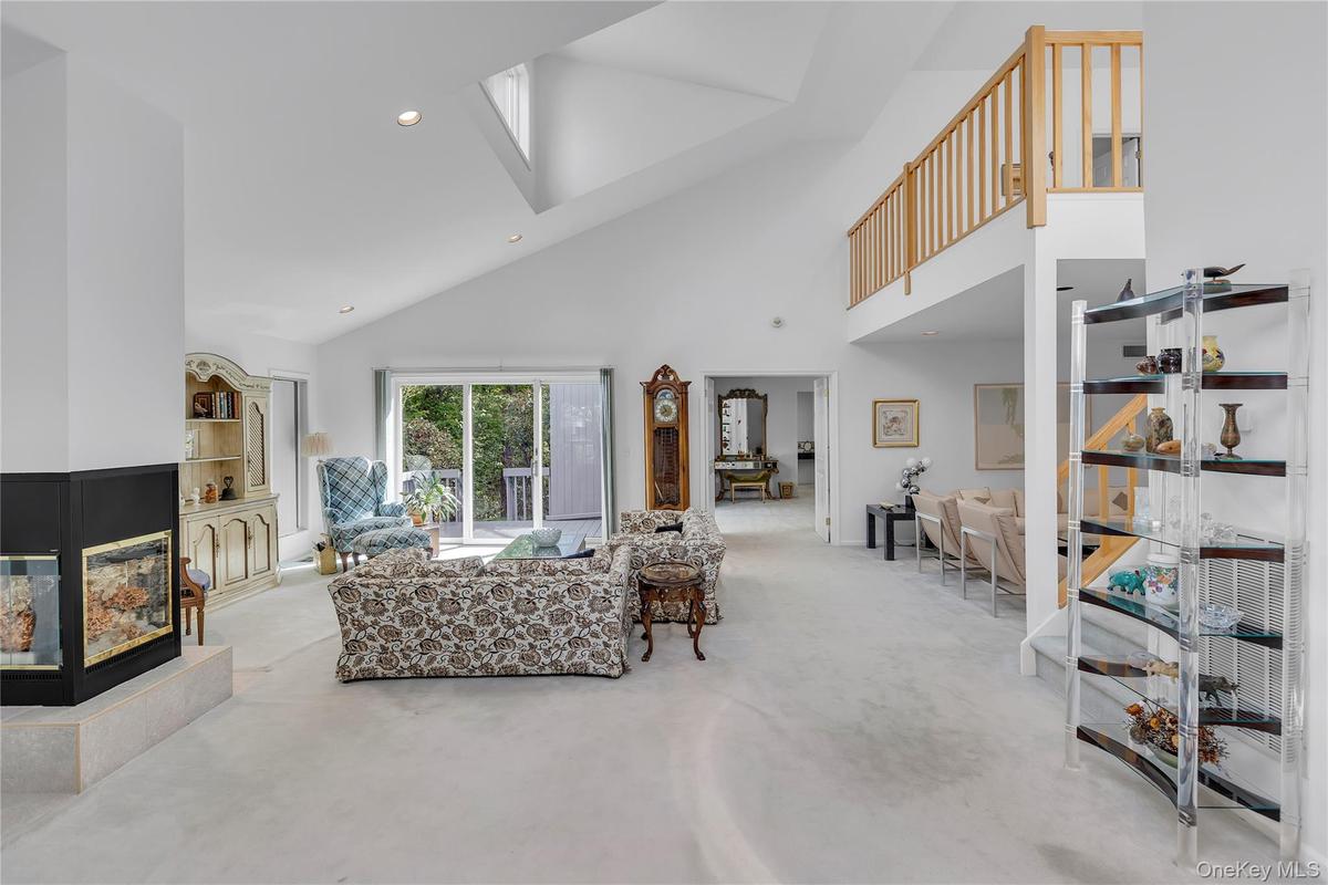 Spacious living area featuring a vaulted ceiling and recessed lighting